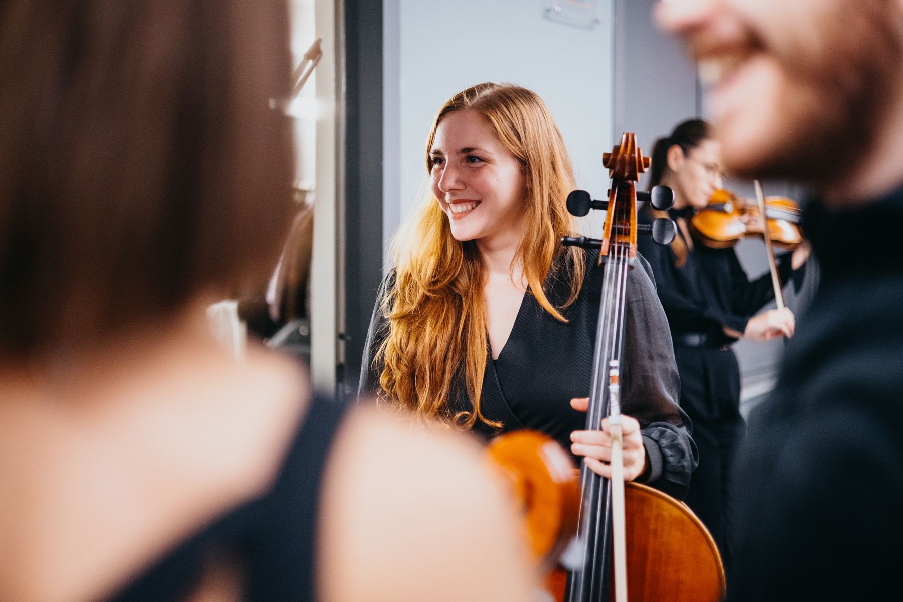 Una violinista dell’ensemble sorride dietro le quinte