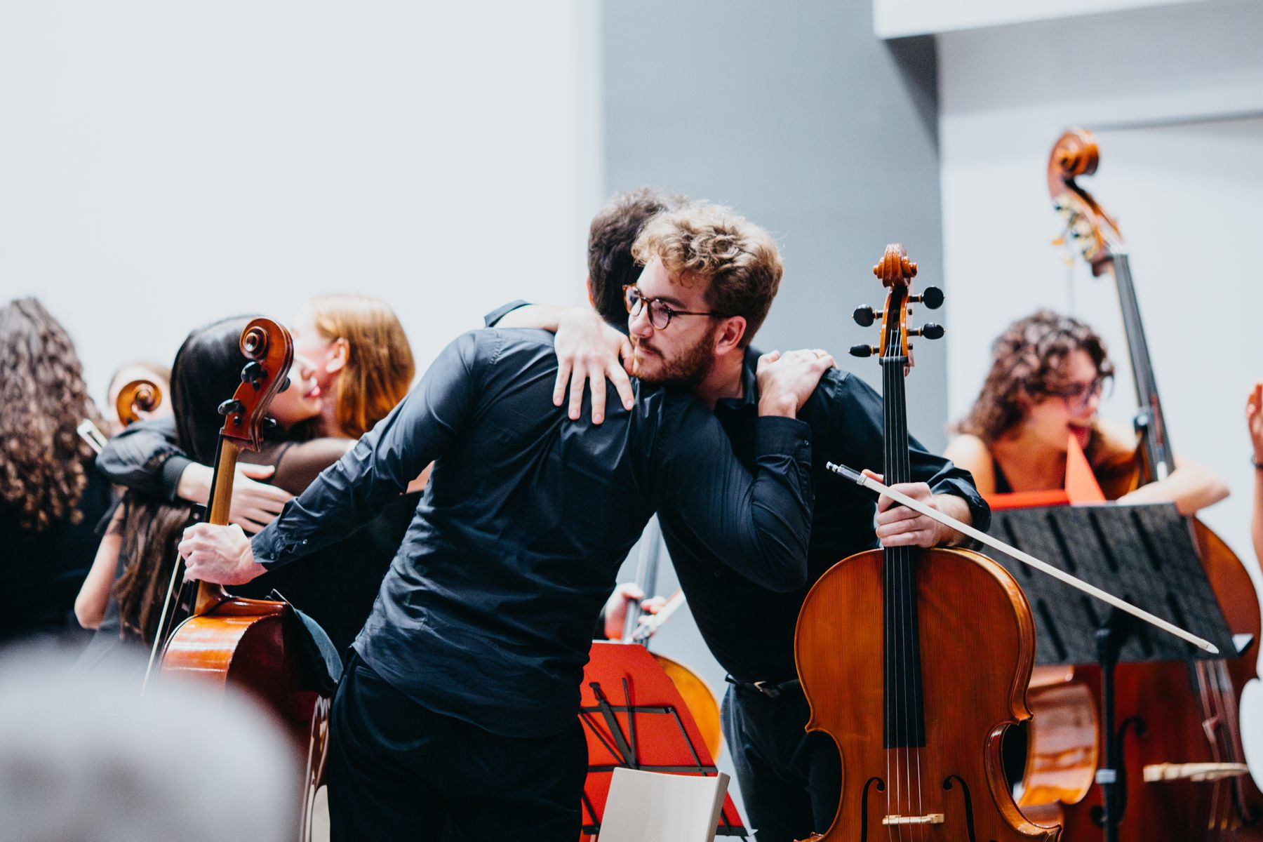 Due musicisti dell’ensemble si abbracciano dietro le quinte